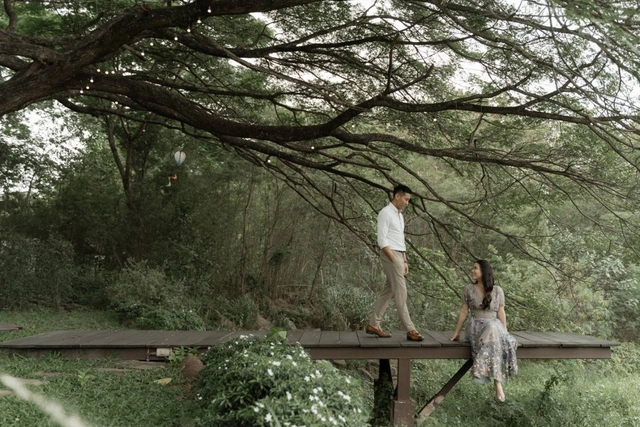 Mauric and Nadya together on a wooden walkway beneath the trees